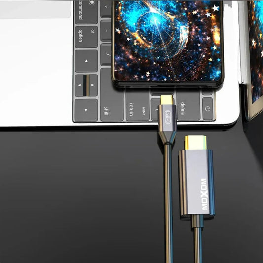 MOXOM device connecting to a laptop with a smartphone displaying a space-themed wallpaper.